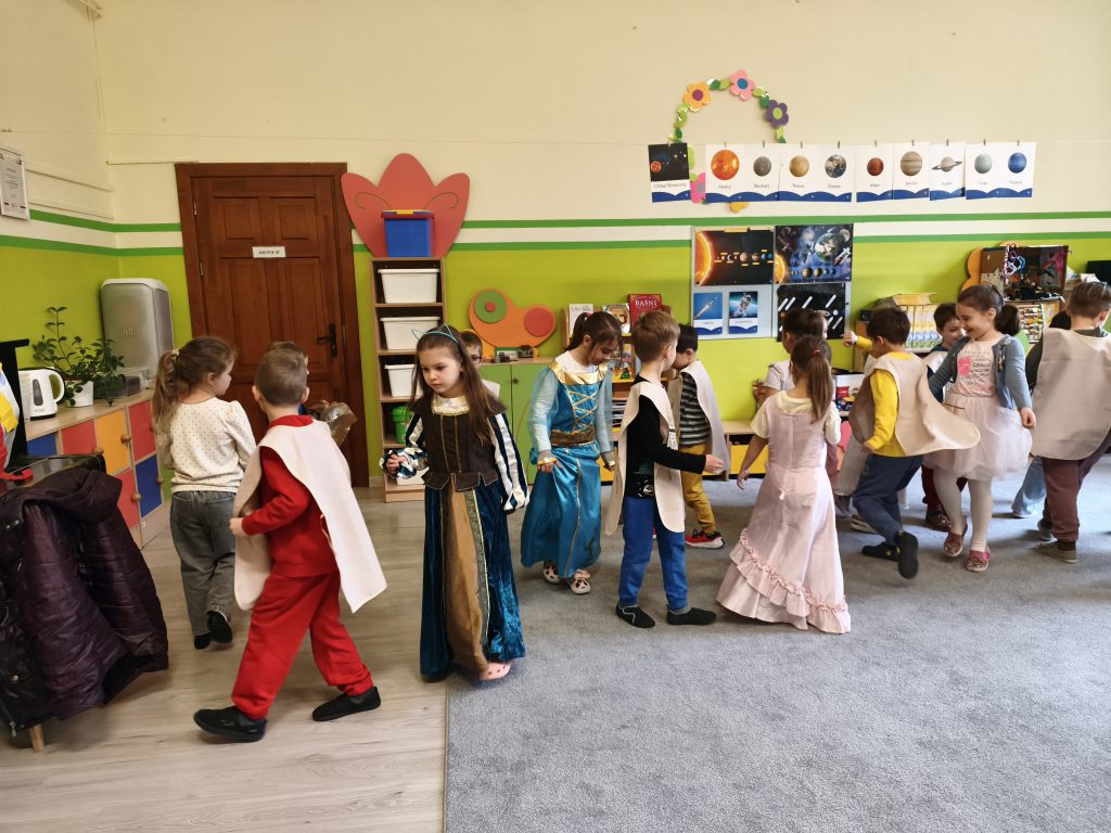 Grupa dzieci podczas tańca dawnego. Dzieci przebrane w stroje dam i rycerzy.
